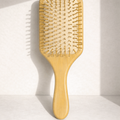 Wooden paddle brush on a light background