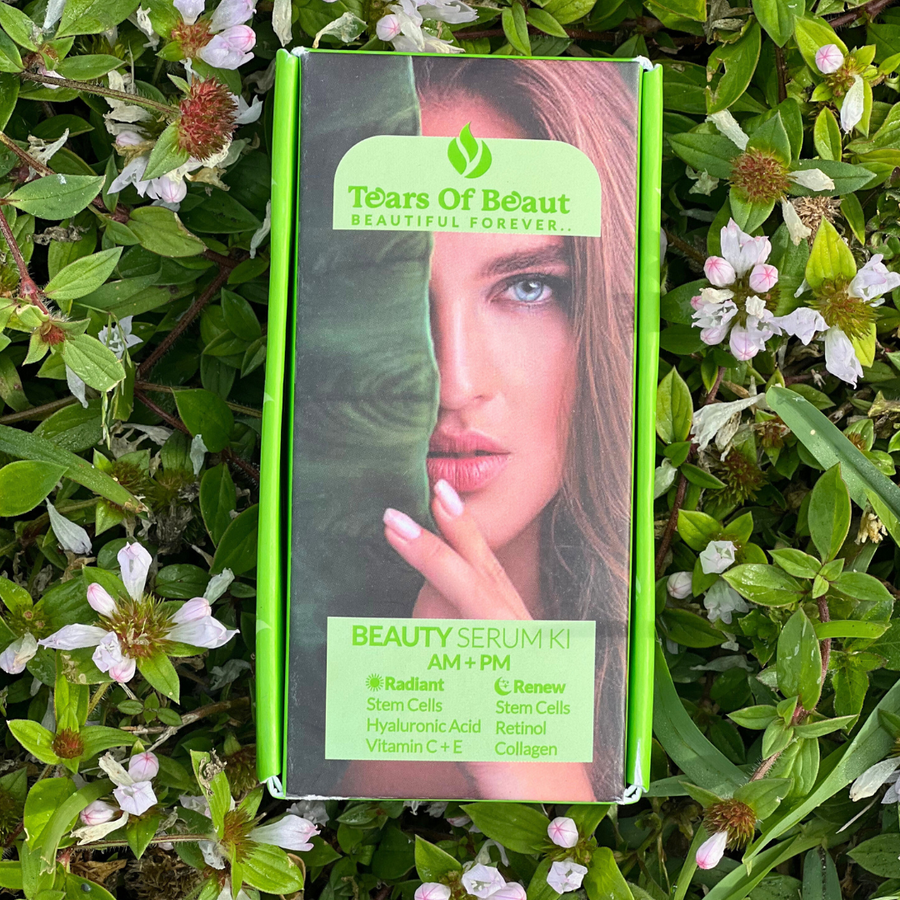 Tears of Beauty AM+PM serum box with a woman's face, green leaf, and product details on green foliage.